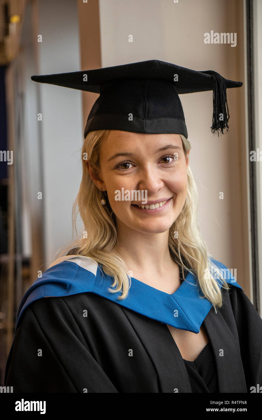 Hübsche Studentin in ihrem Kleid und mortarboard lächelnd Stockfoto