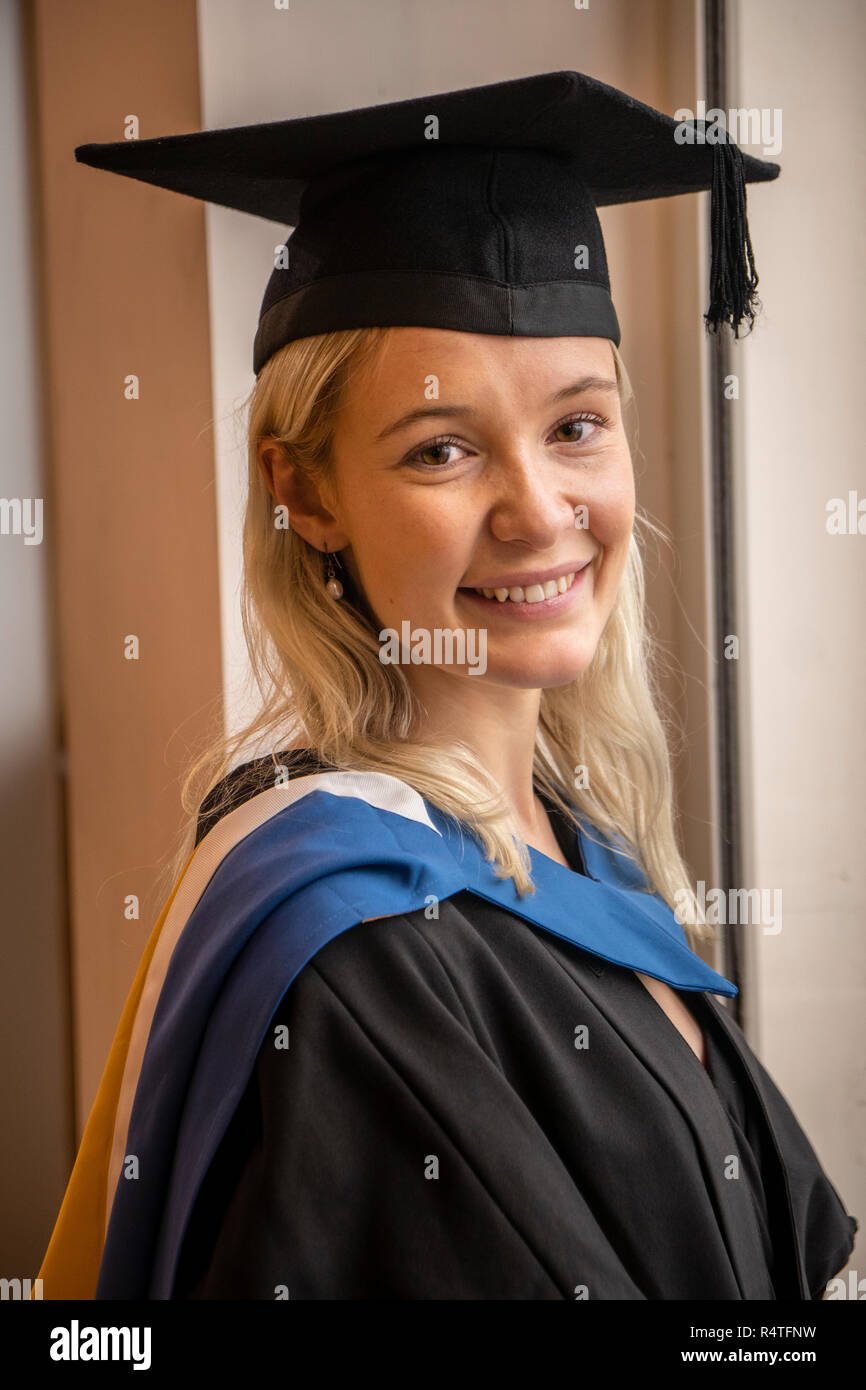 Hübsche Studentin in ihrem Kleid und mortarboard lächelnd Stockfoto