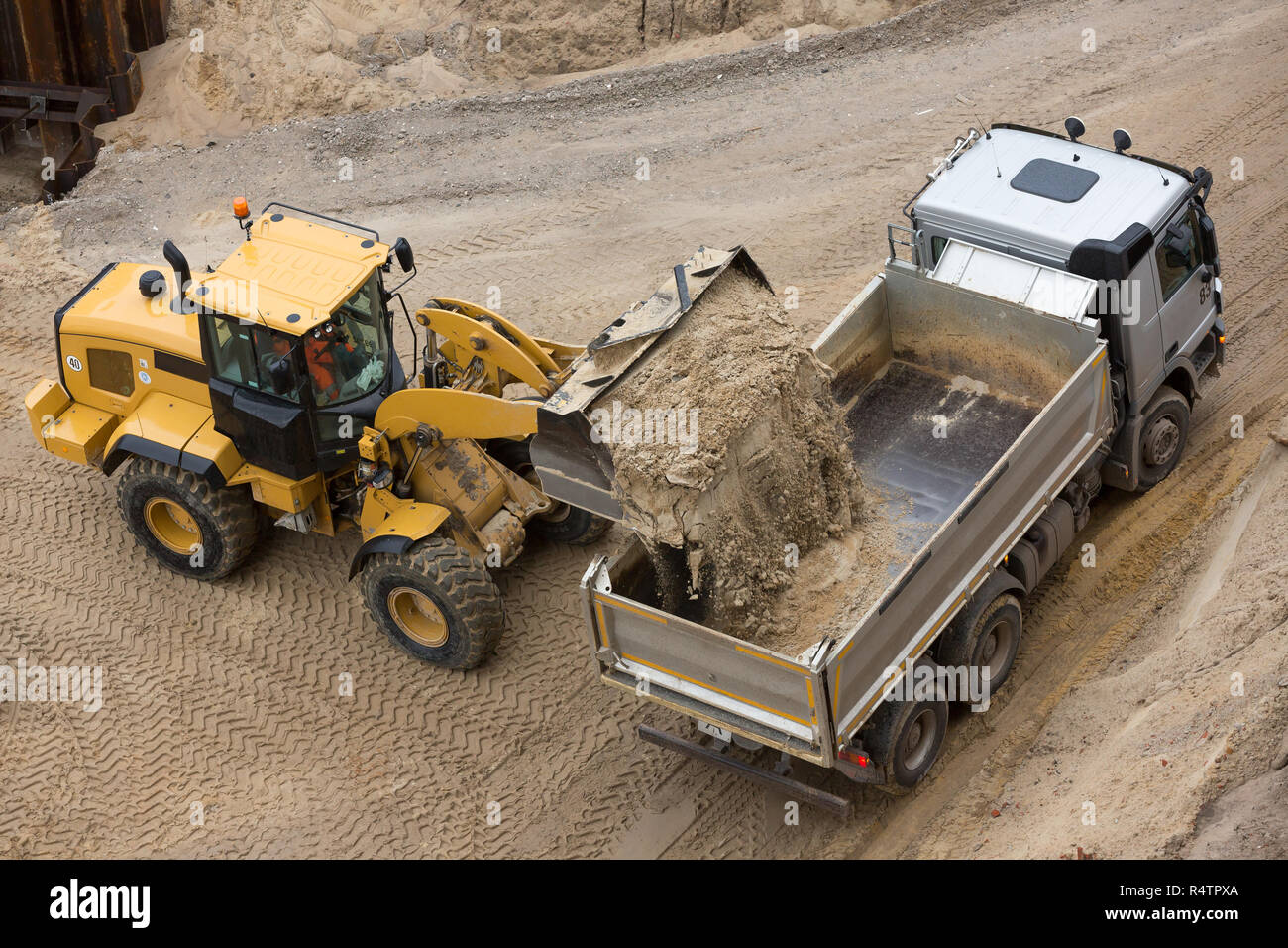 Radlader befüllen Sand auf einem Lkw Stockfoto