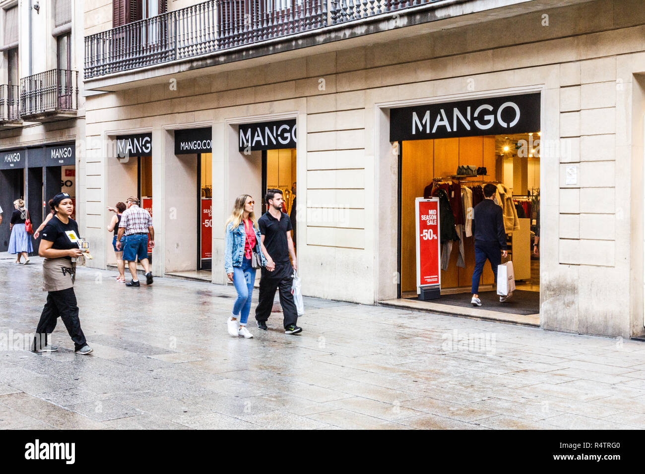 Barcelona, Spanien - 4. Oktober 2017: Menschen zu Fuß vorbei an der Mango Clothing Store. Die Marke ist in der Stadt gehabt. Stockfoto