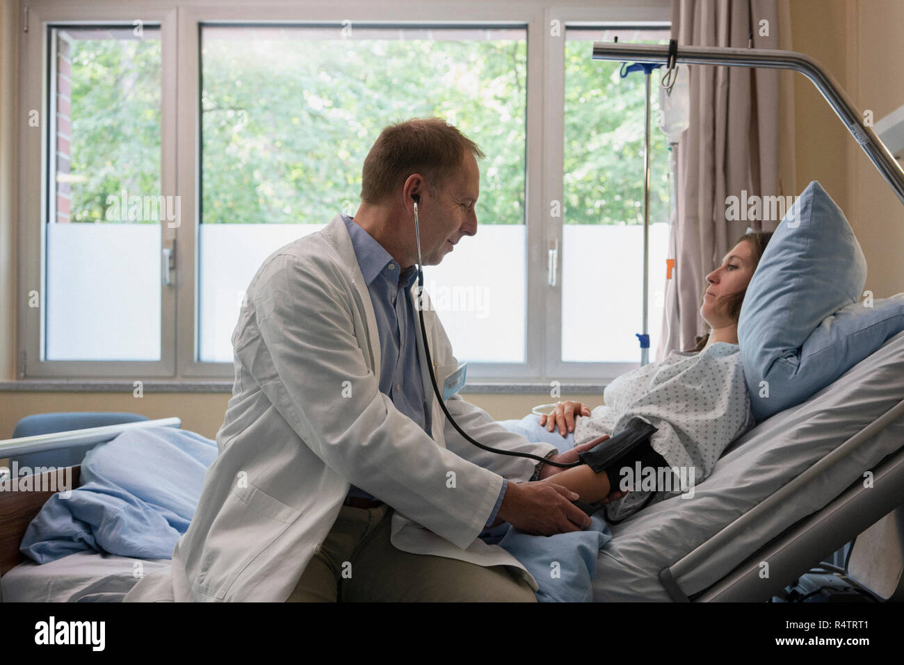 Visite machen, Kontrolle der Blutdruck des Patienten im Krankenhaus Zimmer Stockfoto