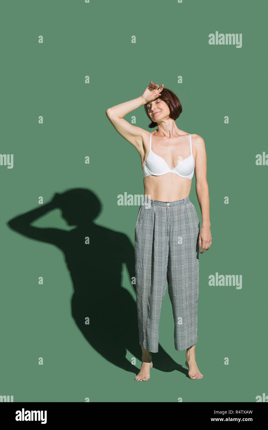 Porträt müde Frau in Bh gegen grüner Hintergrund Stockfoto