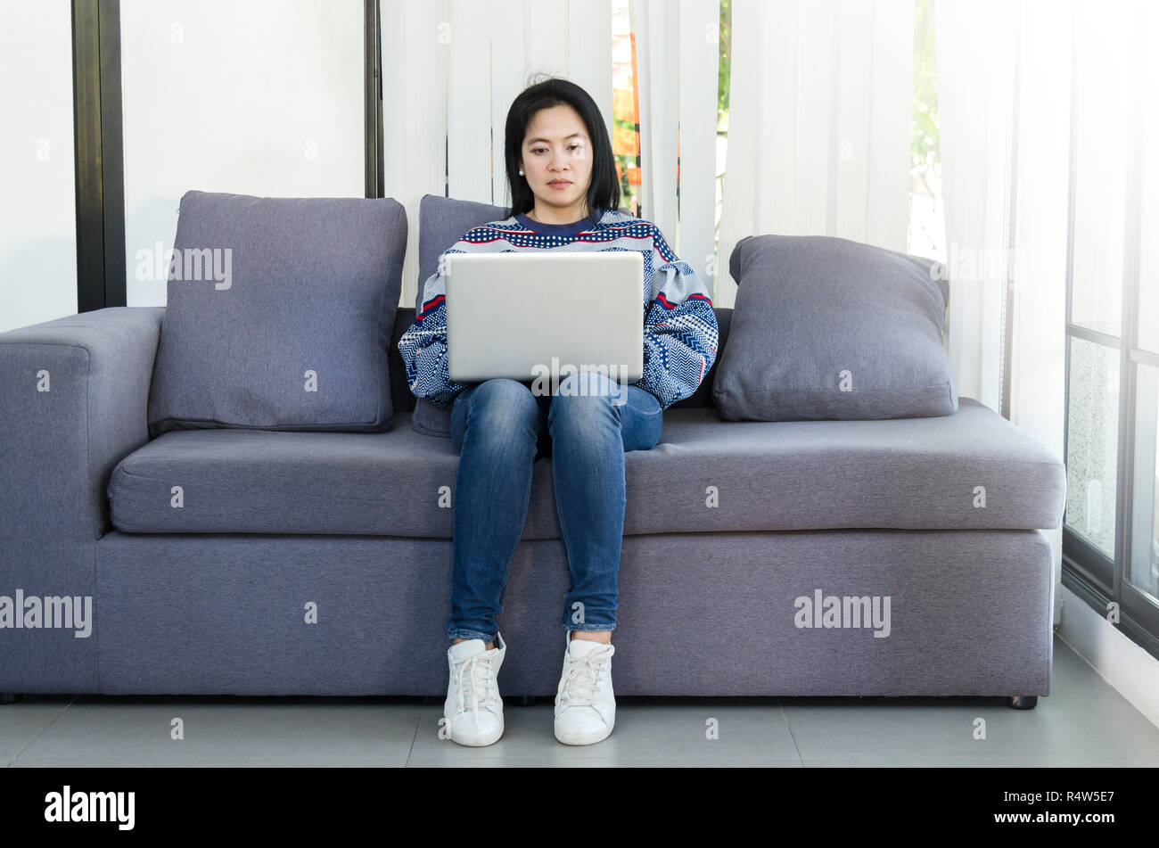 Frau mit Computer Laptop auf dem Sofa in Ihrem Haus. Stockfoto