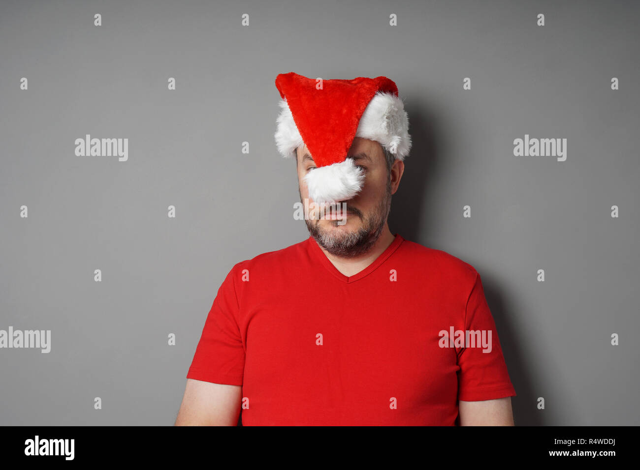 Weihnachten hater ausblenden Gesicht hinter Santa Hut Stockfoto