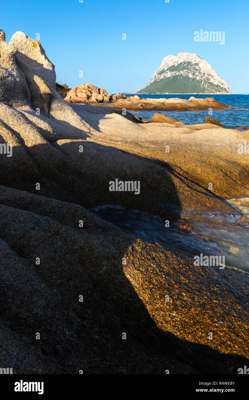 Schatten auf dem Fels mit Insel Tavolara im Hintergrund. Loiri Porto San Paolo Olbia Tempio Provinz, Sardinien, Italien, Europa. Stockfoto