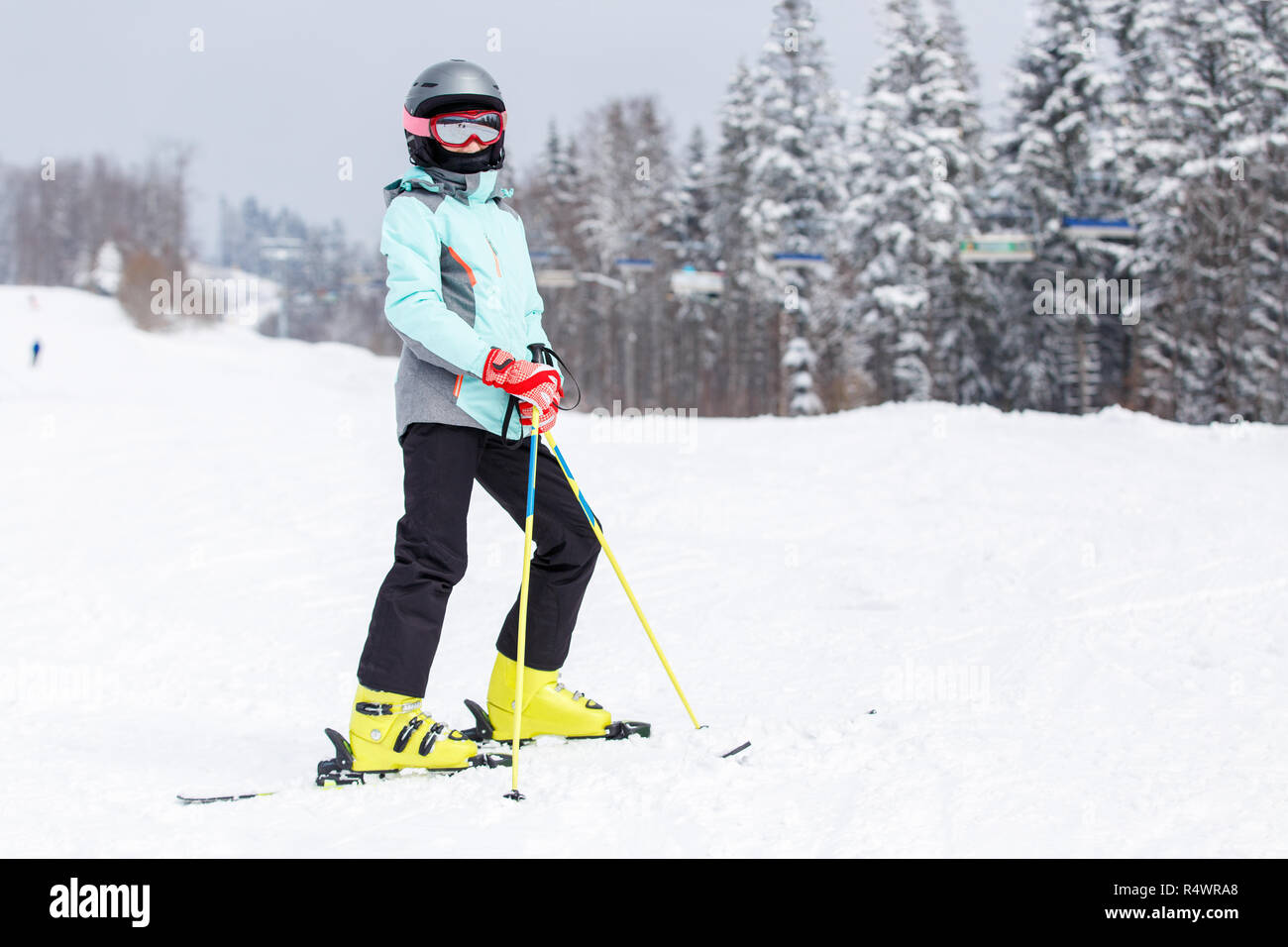Jugendmädchen in Helm auf dem Berghang bei Ski Resort Stockfoto