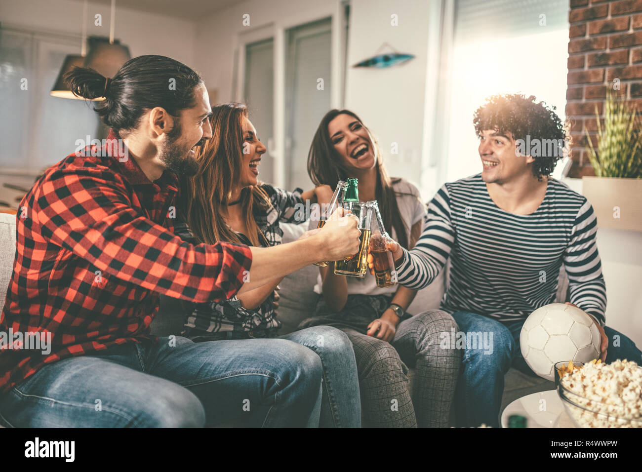 Freunde sind Fans von Sport Spiele wie Fußball lieben ihre Freizeit zu Hause zusammen. Sie sind Schreiend und gestikulierend für einen Sieg. Stockfoto