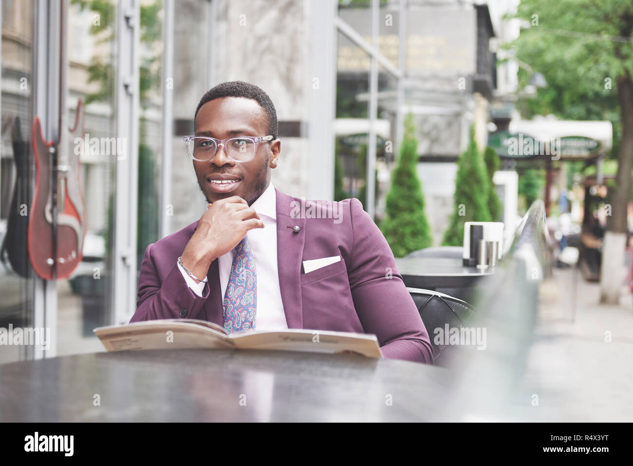 Eine schöne Afrikanische amerikanische Geschäftsmann liest ein Menü in einem Cafe Stockfoto