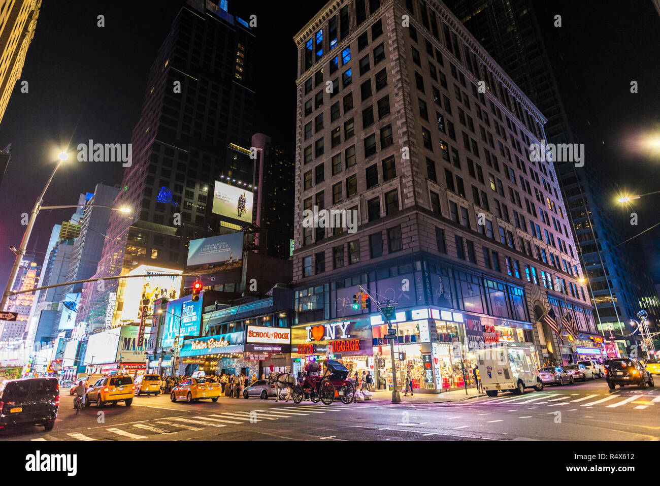 New York City, USA - 30. Juli 2018: Taxi und Geschäfte in der Nacht auf der Seventh Avenue (7. Avenue) Neben der Times Square mit Menschen in Manhattan in New Stockfoto