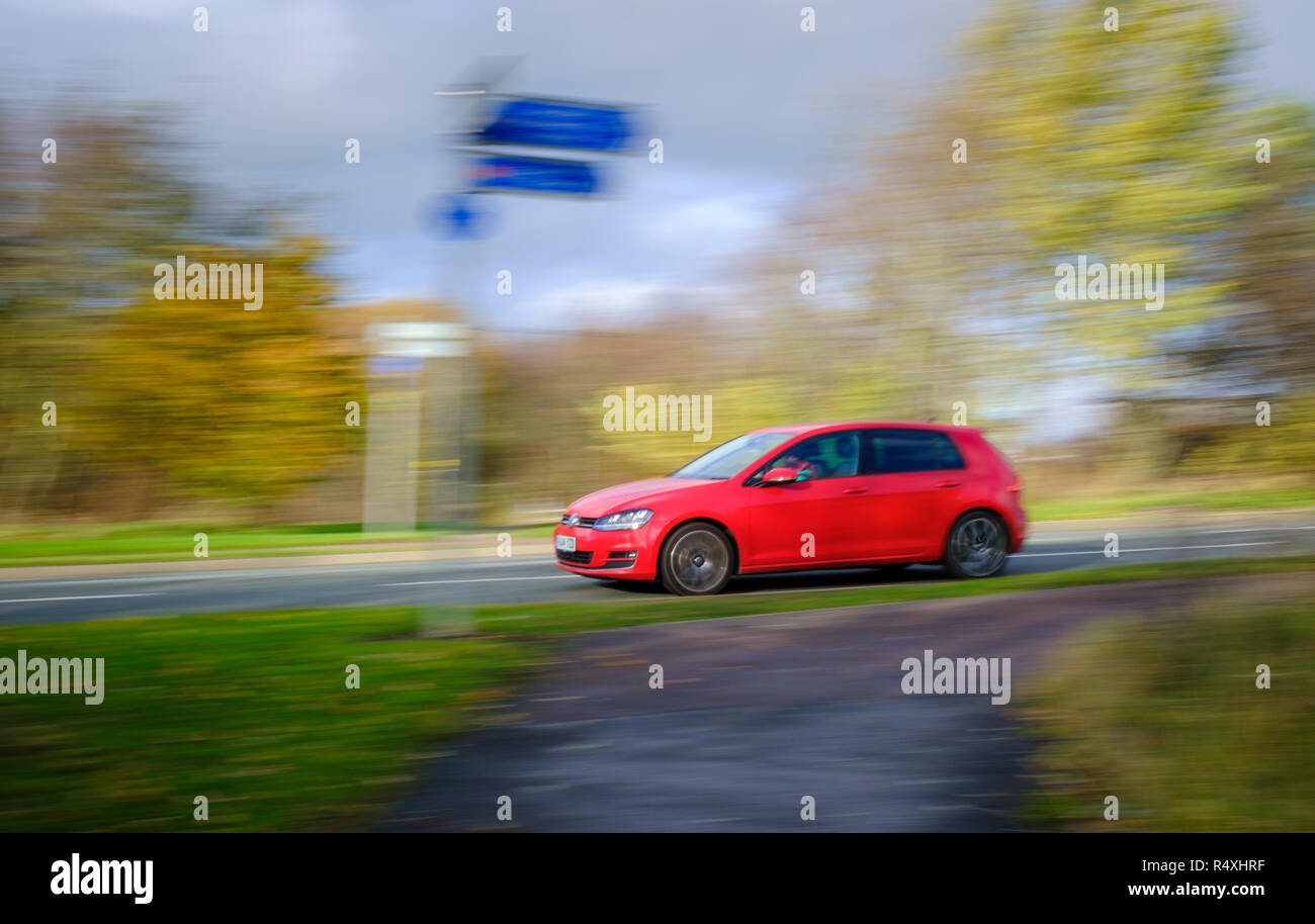 Panning Aufnahme von sich schnell bewegenden rotes Auto mit Geschwindigkeit verwischen Stockfoto