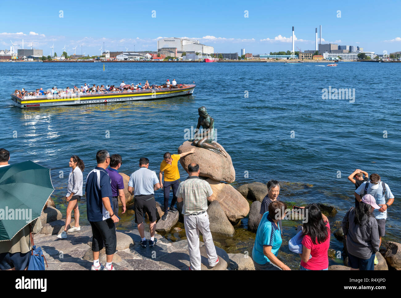 Chinesische Touristen für Bilder von Die kleine Meerjungfrau (Den Lille Havfrue), Kopenhagen, Dänemark posing Stockfoto