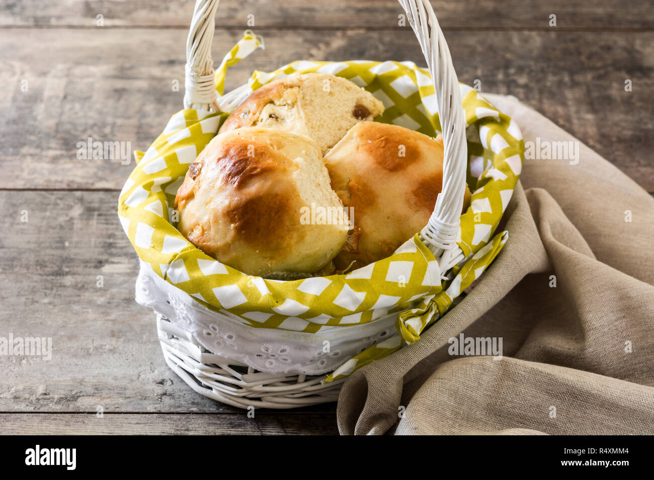 Schöne traditionelle Ostern Hot Cross Buns in einem Korb auf hölzernen Tisch Stockfoto Schöne traditionelle Ostern Hot Cross Buns in einem Korb auf hölzernen Tisch Stockfoto