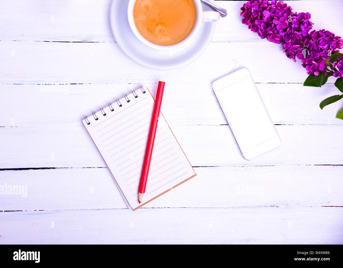 Leere kleines Notizbuch mit einem roten Stift und ein Handy auf einem weißen Holz- Oberfläche Stockfoto