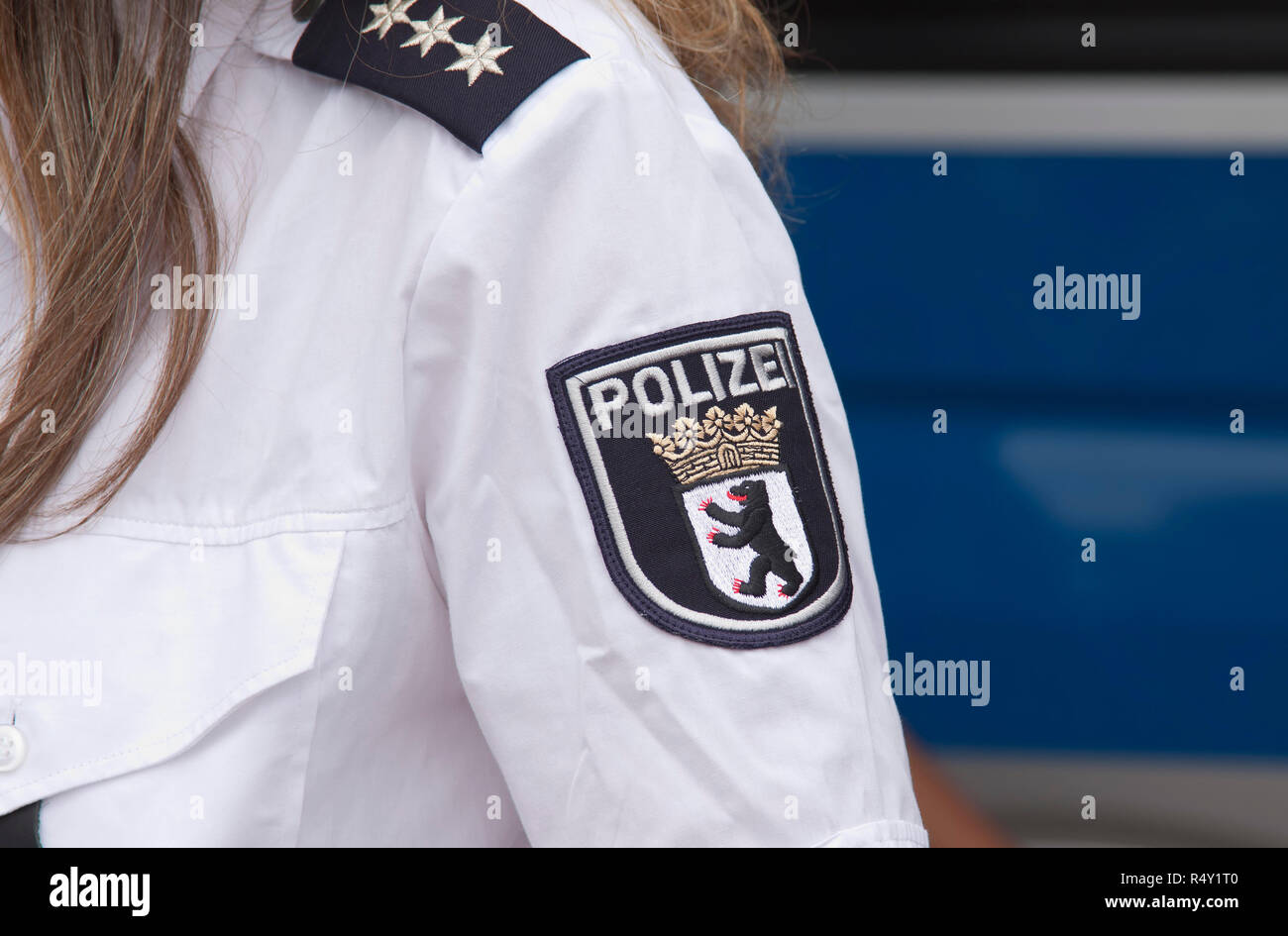 Polizeiabzeichen der Berliner Polizei und Abzeichen eines Chefinspektors auf dem weißen Ärmel einer Polizistin Stockfoto