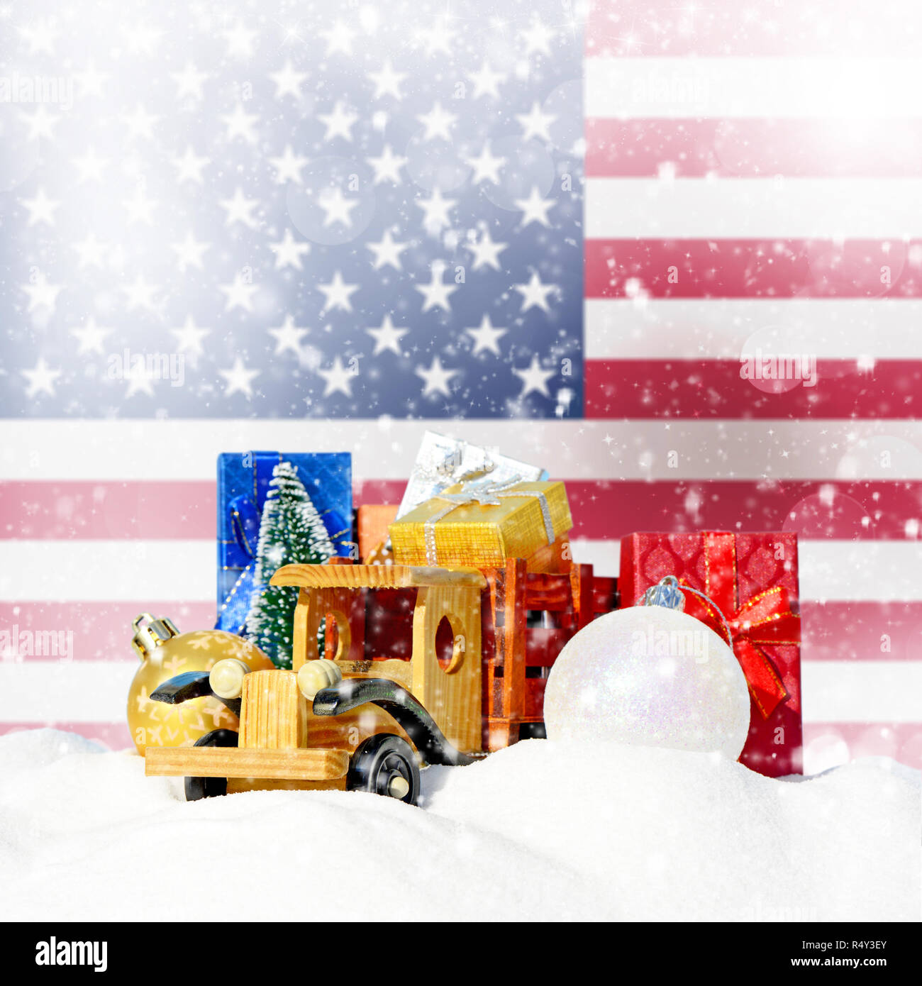 Weihnachten Hintergrund. Spielzeug-LKW mit Geschenken, Neues Jahr Tanne, Kugeln im Schneetreiben und Amerikanische Flagge Stockfoto