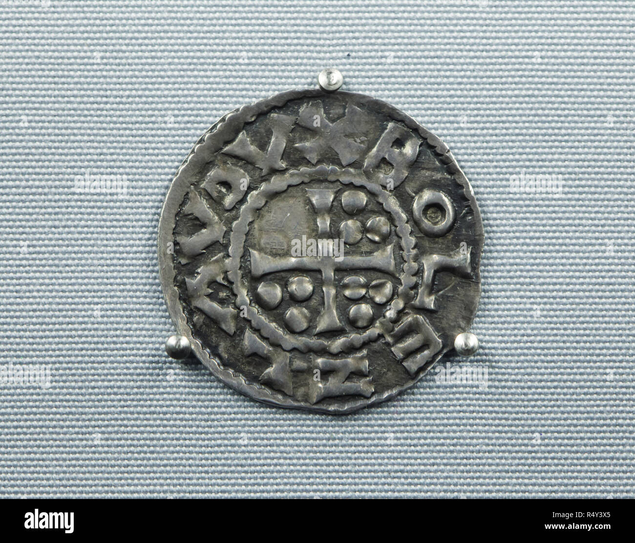 Die älteste Tschechische Münze aus dem 10. Jahrhundert datiert auf Anzeige an der Ausstellung im Nationalmuseum (Národní Muzeum) in Prag, Tschechische Republik. Die mittelalterlichen böhmischen Silber münze (denar) in Prag unter der Herrschaft des Herzogs Boleslaw ich die Grausame minted vor 966 gilt als die älteste erhaltene Münze zu sein, im Gebiet, das heute das Tschechische Republik geprägt. Ein Kreuz mit neun dotes ist in die Münze mit einer Inschrift um 'BOLEZLAV DVX' ('Duke Boleslaw") dargestellt. Die Ausstellung zum 200. Jahrestag des Nationalen Museum präsentiert 200 der wichtigsten Elemente aus Stockfoto