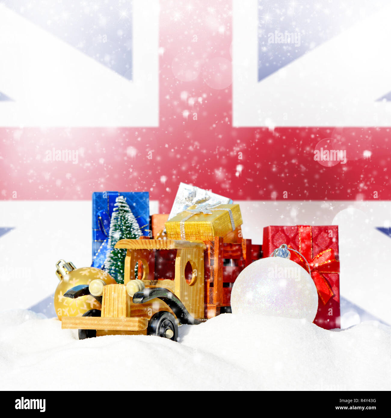 Weihnachten Hintergrund. Spielzeug-LKW mit Geschenken, Neues Jahr Tanne, Kugeln im Schneetreiben und England Flagge Stockfoto