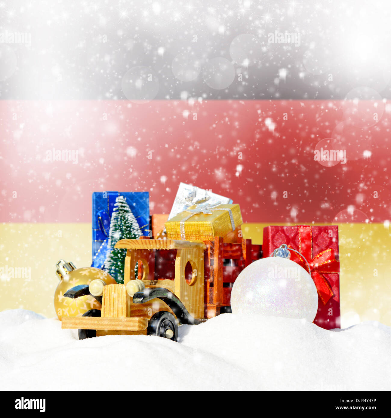 Weihnachten Hintergrund. Spielzeug-LKW mit Geschenken, Neues Jahr Tanne, Kugeln im Schneetreiben und Deutsche Flagge Stockfoto