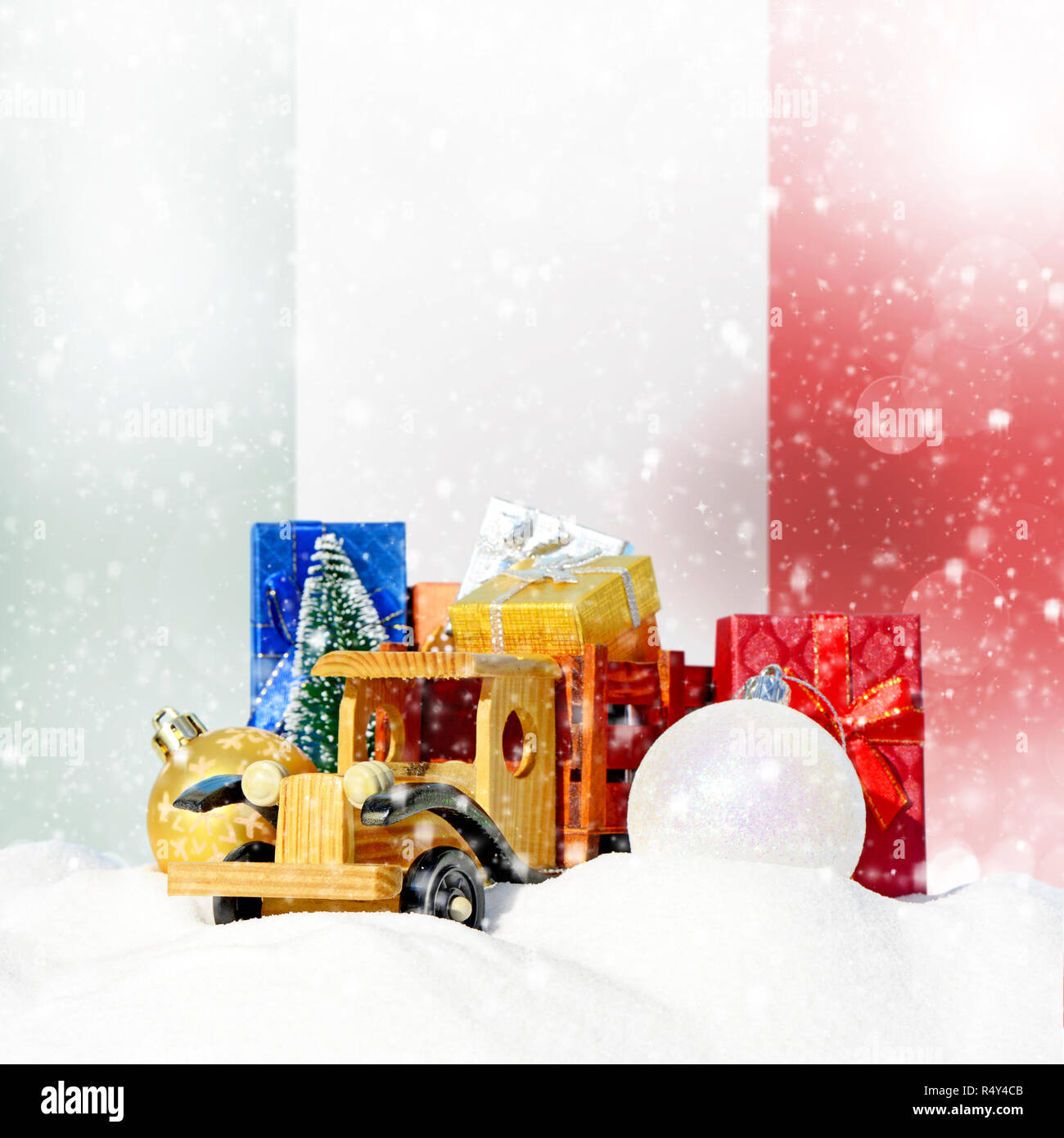 Weihnachten Hintergrund. Spielzeug-LKW mit Geschenken, Neues Jahr Tanne, Kugeln im Schneetreiben und italienische Flagge Stockfoto