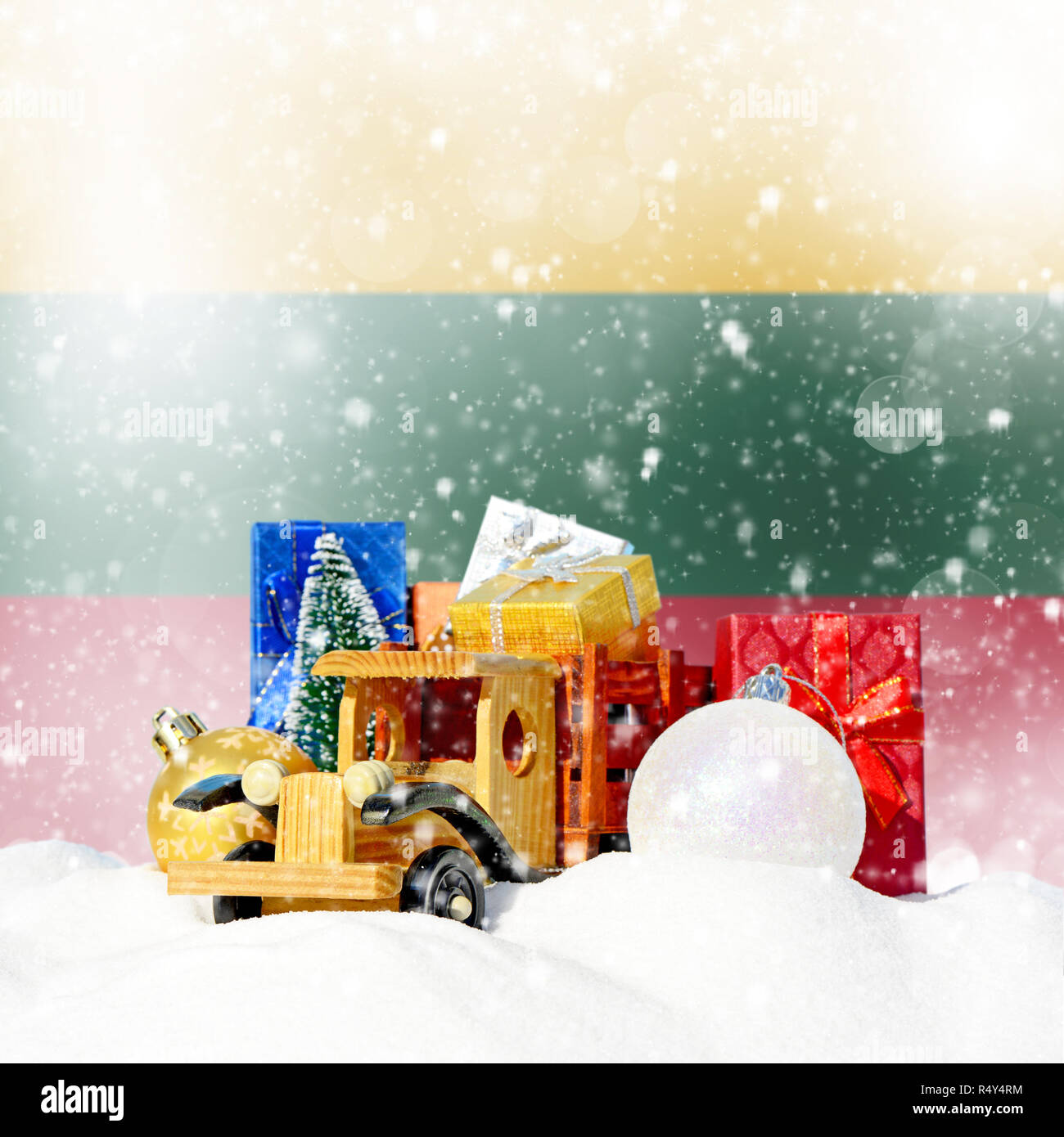 Weihnachten Hintergrund. Spielzeug-LKW mit Geschenken, Neues Jahr Tanne, Kugeln im Schneetreiben und litauischer Flagge Stockfoto