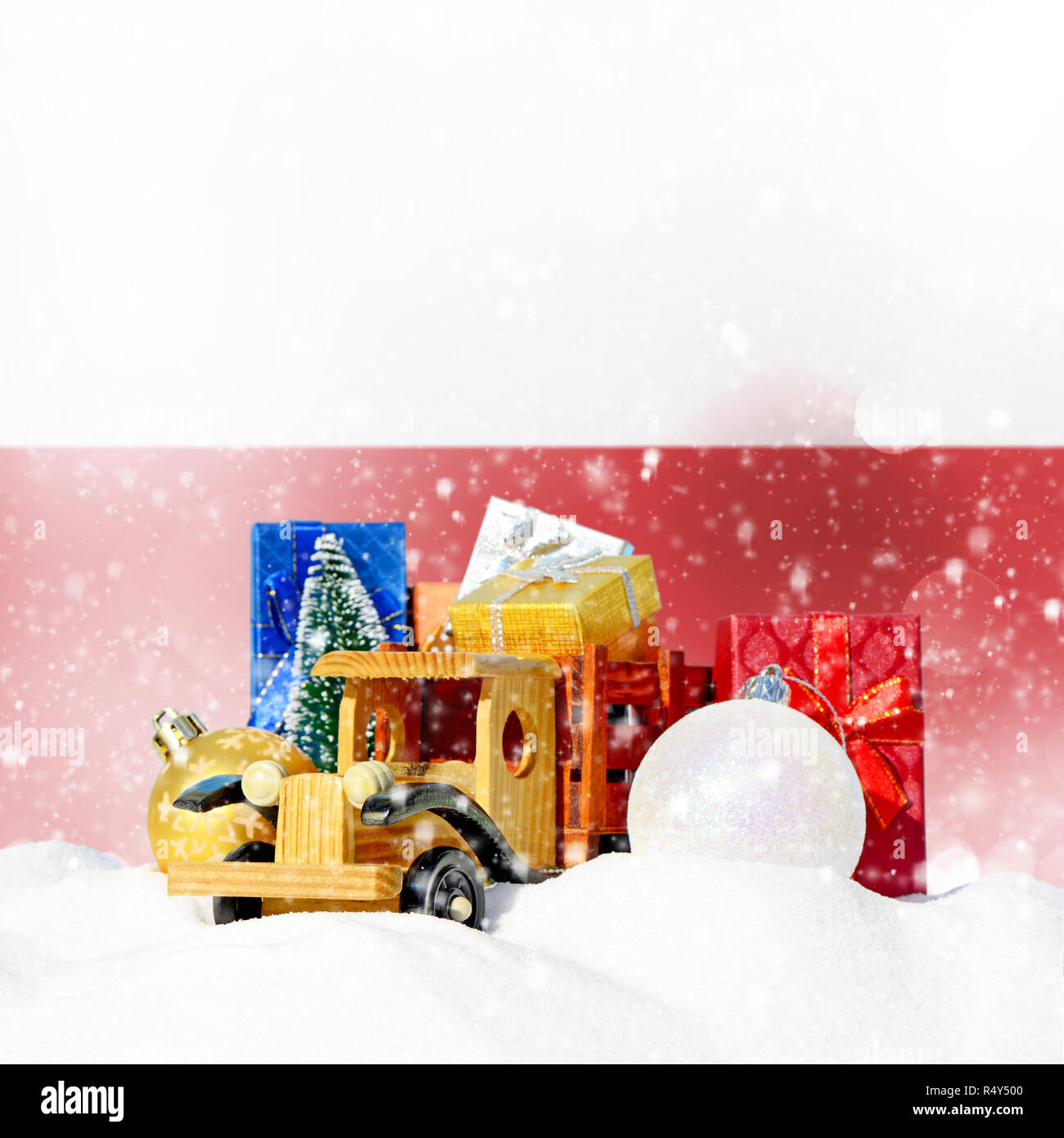 Weihnachten Hintergrund. Spielzeug-LKW mit Geschenken, Neues Jahr Tanne, Kugeln im Schneetreiben und Polnische Flagge Stockfoto