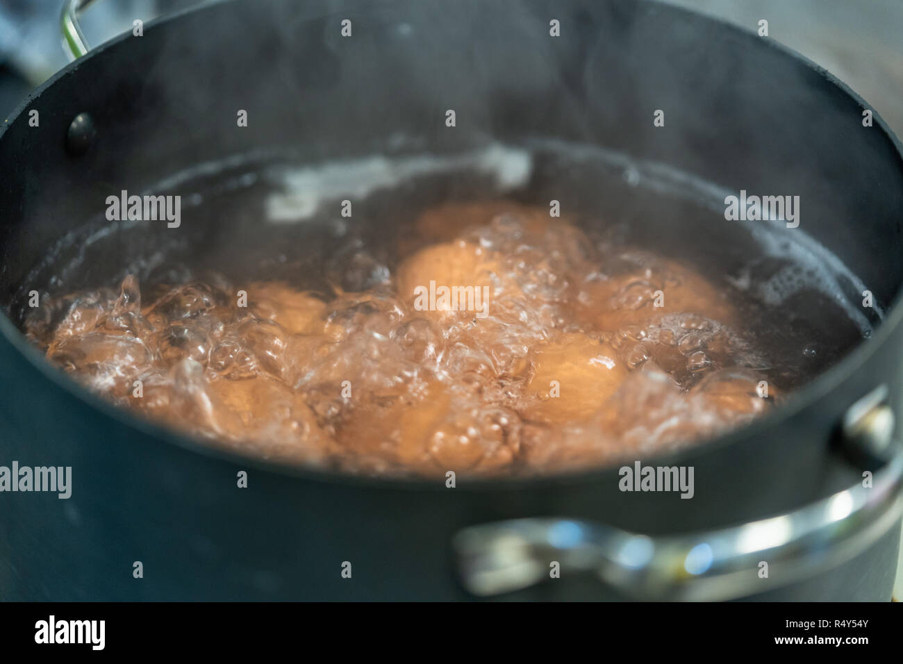 Eier kochen in Wasser - Detailansicht mit Rauch teilweise für den Frame Stockfoto