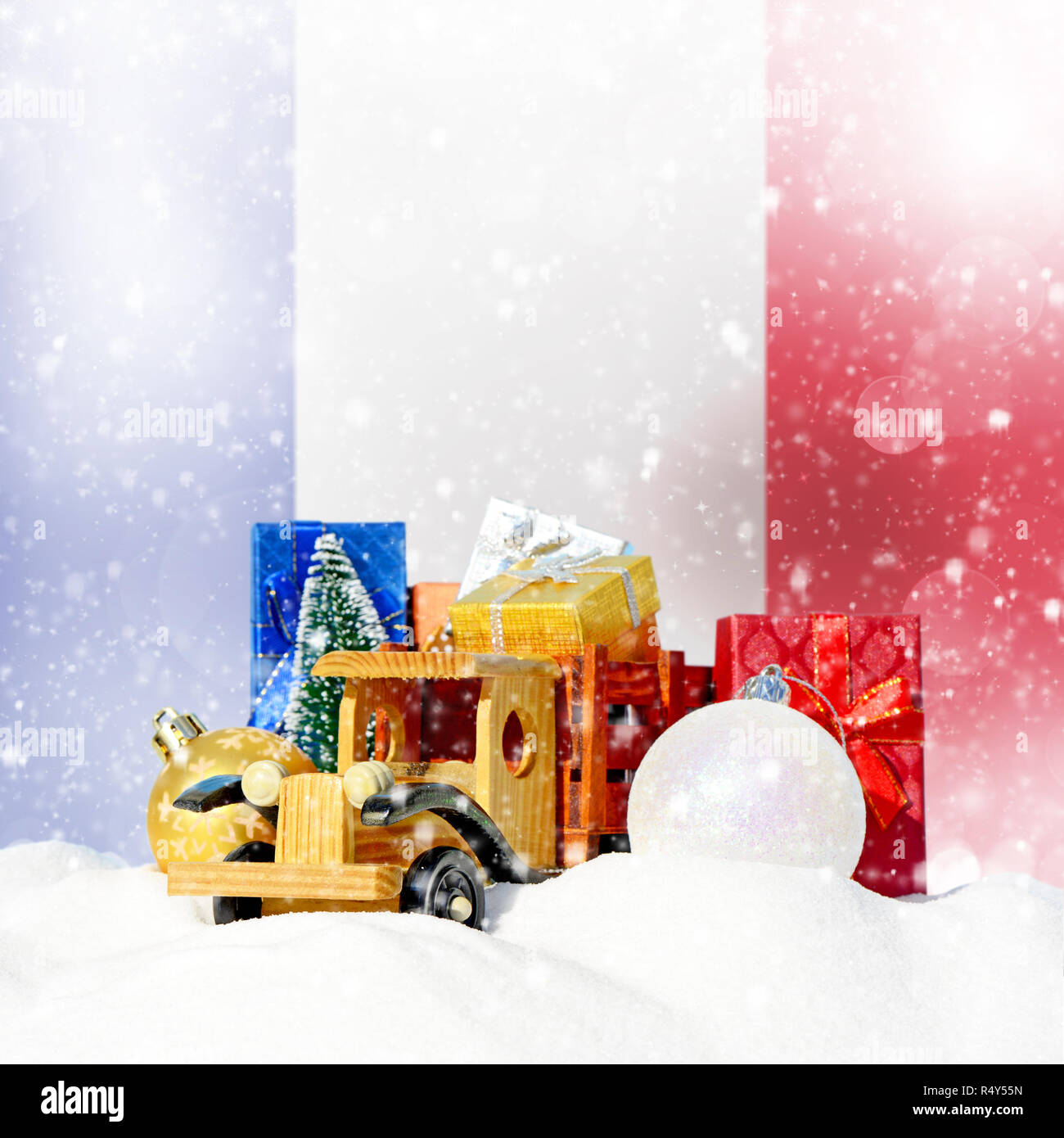 Weihnachten Hintergrund. Spielzeug-LKW mit Geschenken, Neues Jahr Tanne, Kugeln im Schneetreiben und French Flag Stockfoto