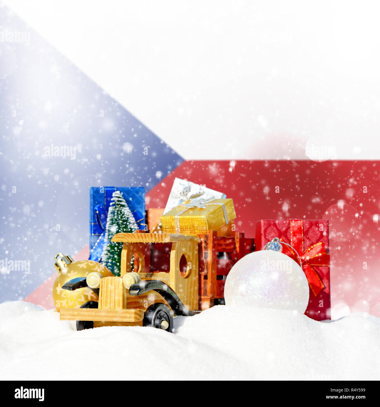Weihnachten Hintergrund. Spielzeug-LKW mit Geschenken, Neues Jahr Tanne, Kugeln im Schneetreiben und Tschechische Republik Flagge Stockfoto
