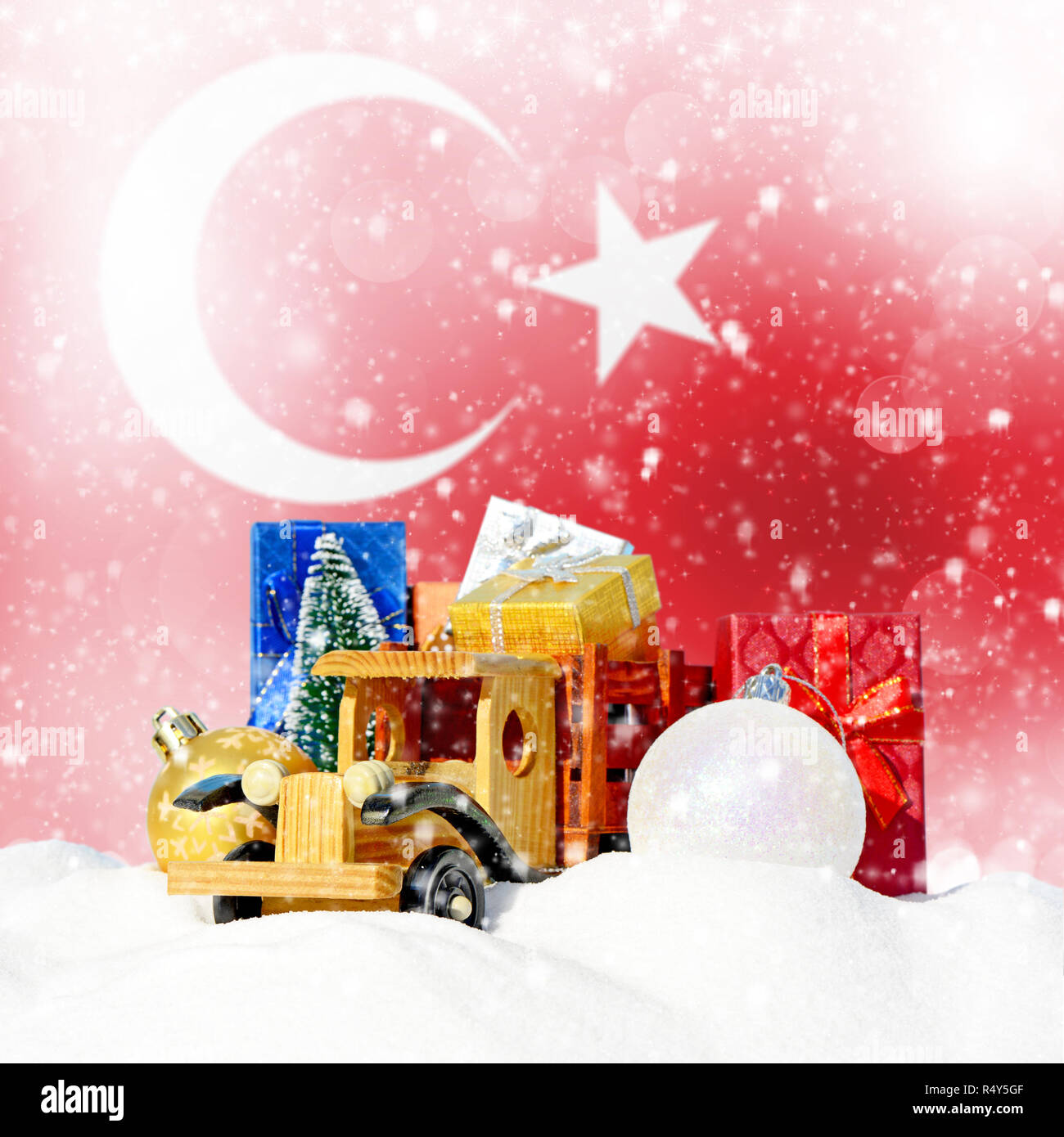 Weihnachten Hintergrund. Spielzeug-LKW mit Geschenken, Neues Jahr Tanne, Kugeln im Schneetreiben und Türkische Flagge Stockfoto