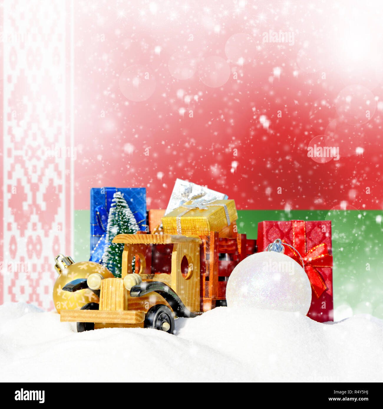 Weihnachten Hintergrund. Spielzeug-LKW mit Geschenken, Neues Jahr Tanne, Kugeln im Schneetreiben und weißrussischen Flagge Stockfoto