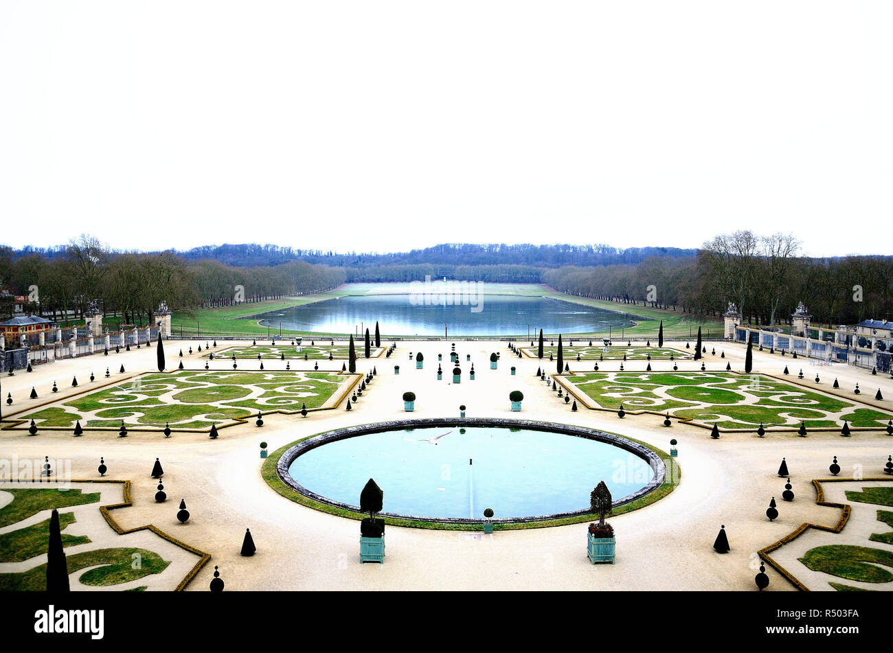 Gärten von Versailles an einem kalten Wintertag in Paris, Frankreich. Gefrorenes Wasser im Brunnen. Noch eine schöne Aussicht und Symmetrie Stockfoto