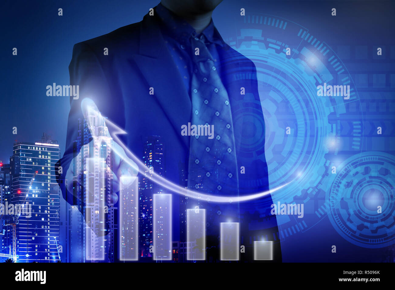 Business Mann am weißen Balken Diagramm für das Wachstum des Unternehmens Konzept und prüft Graphen durch interaktive Anzeige Hintergrund Gebäude Nacht gesehen, s Stockfoto
