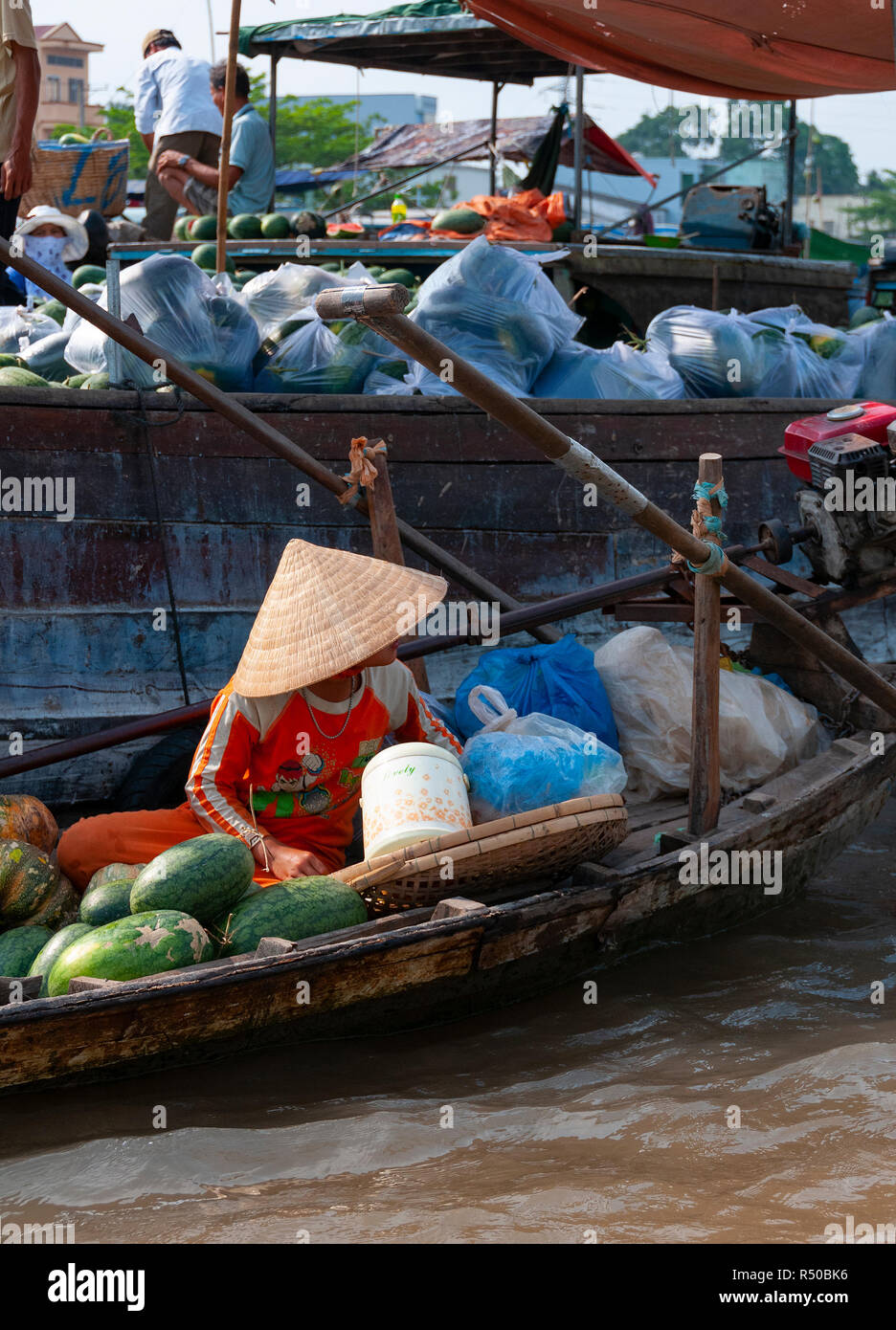 Traditionelle vietnamesische Bäuerin in konischer hat versuchen, ihre Produkte auf dem Cai Rang Floating Market zu verkaufen, in der Provinz Can Tho, Vietnam Stockfoto