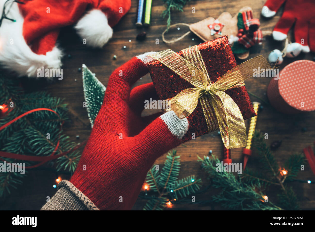 Hand mit Weihnachtsgeschenk verpackt in einer Box für fröhliche Feiertage Stockfoto