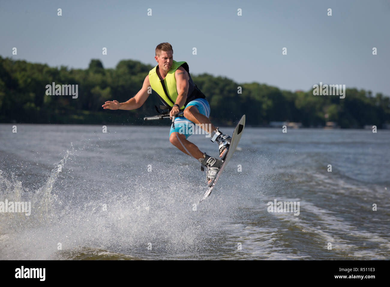 Foto von Mann in der Luft beim Wakeboarden auf dem Fluss Stockfoto