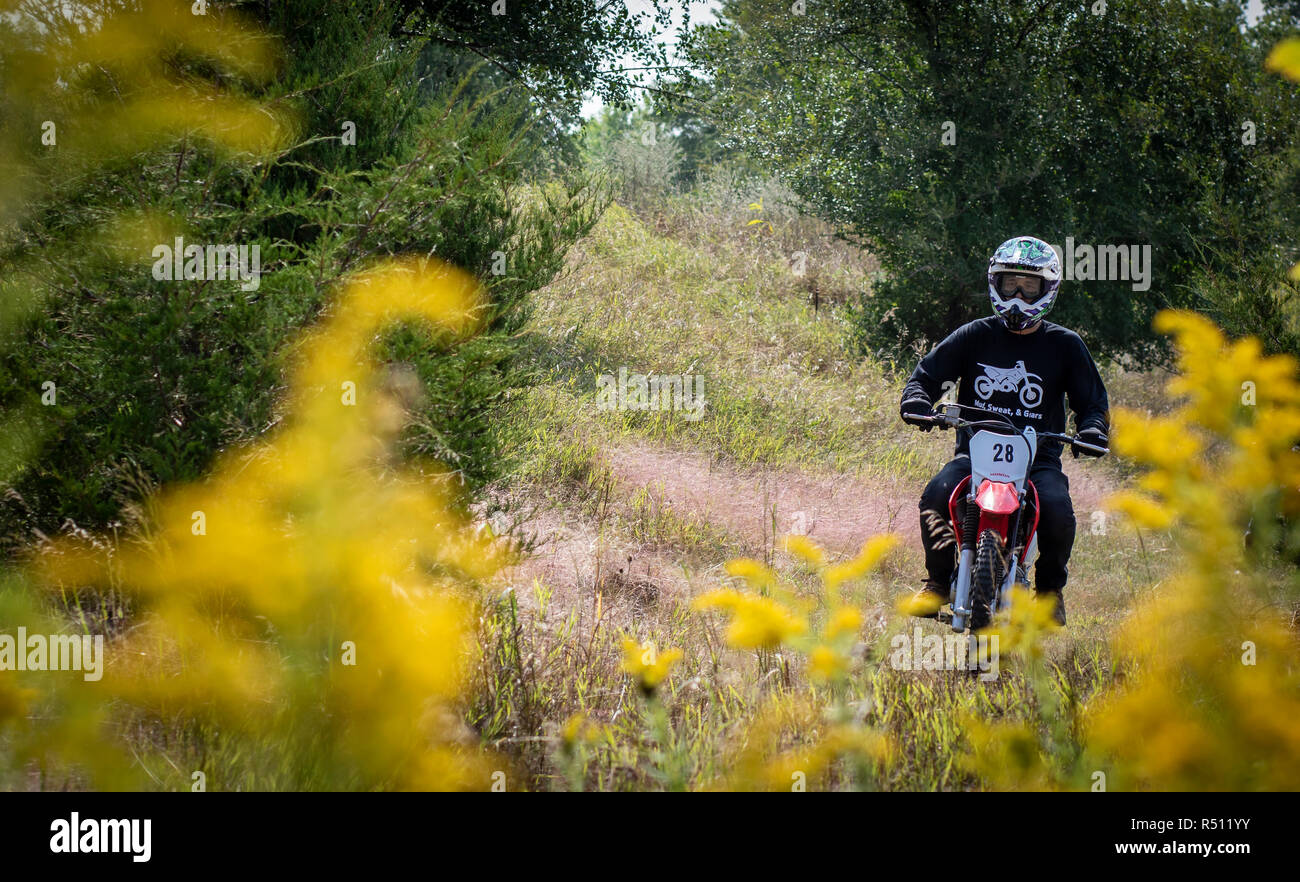 Ansicht von vorn geschossen von einem Mann Motorrad fahren im Wald Stockfoto