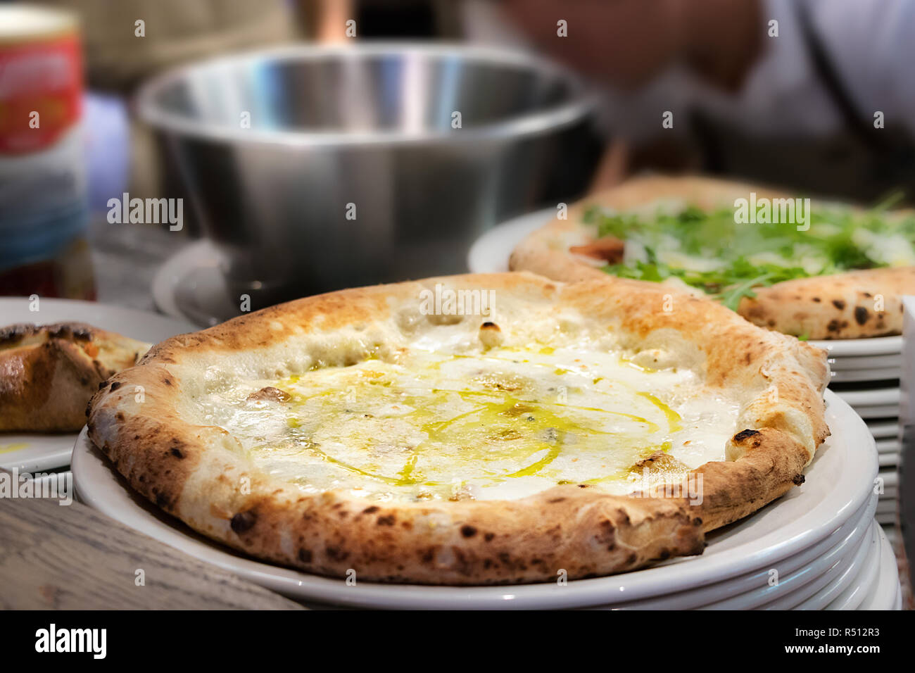 Nahaufnahme der Pizza Margherita auf einem weißen Teller in der Küche bereit, um bedient zu werden. Stockfoto