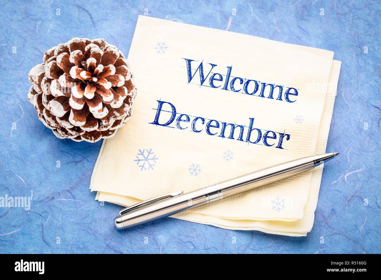 Willkommen im Dezember - Handschrift auf eine Serviette mit einem frostigen Pine Cone Stockfoto