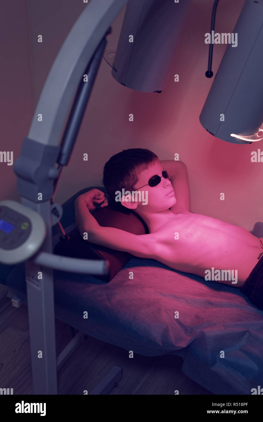 Jungen kaukasischen jungen Verlegung auf Sofa Pflege Bestrahlung immuno-Therapie in der Brust indoor in der Klinik Stockfoto