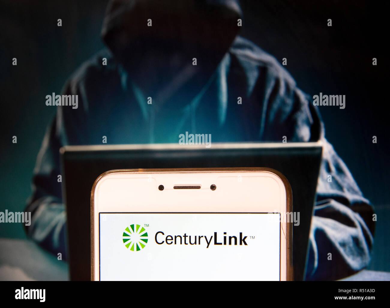 Amerikanische Telekommunikationsunternehmen CenturyLink Logo ist auf ein Android mobile Gerät mit einer Abbildung der Hacker im Hintergrund zu sehen. Stockfoto