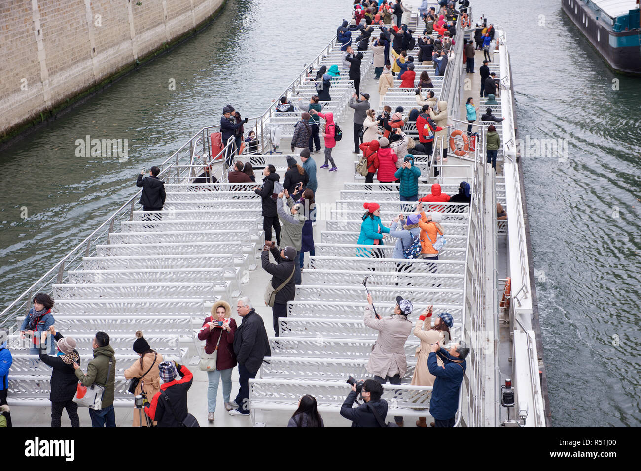 Touristen auf einem Ausflugsboot mit Kameras in Paris, Frankreich Stockfoto