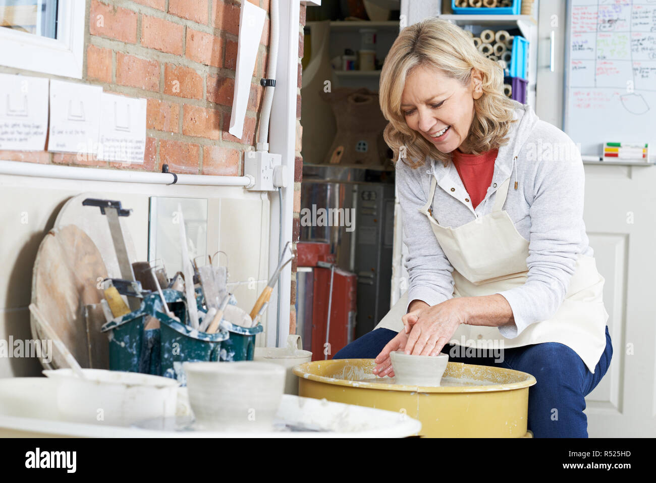 Reife Frau, die Arbeiten an der Töpferscheibe In Studio Stockfoto