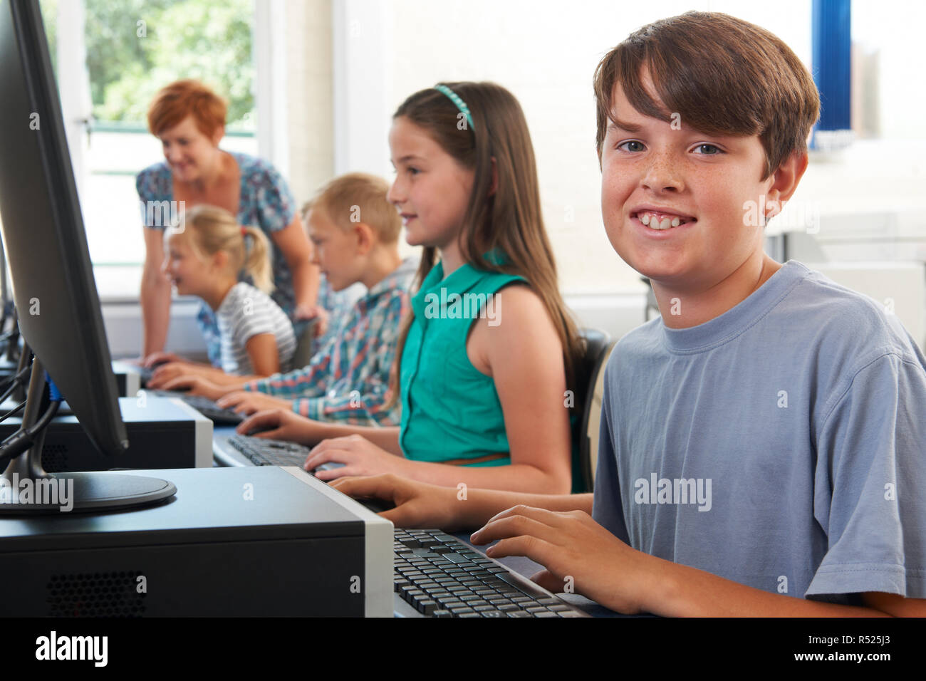 Portrait der männlichen Schüler in der Grundschule Computer Klasse mit Lehrer Stockfoto