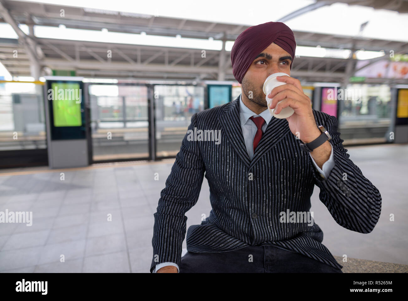 Indischer Geschäftsmann Kaffee trinken am Bahnhof Stockfoto