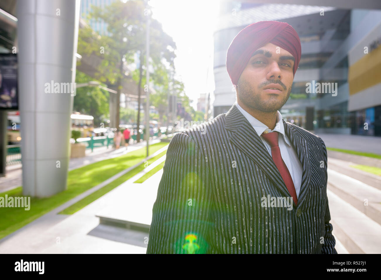 Portrait von indischer Geschäftsmann im Freien in Stadt mit Lens flare Stockfoto