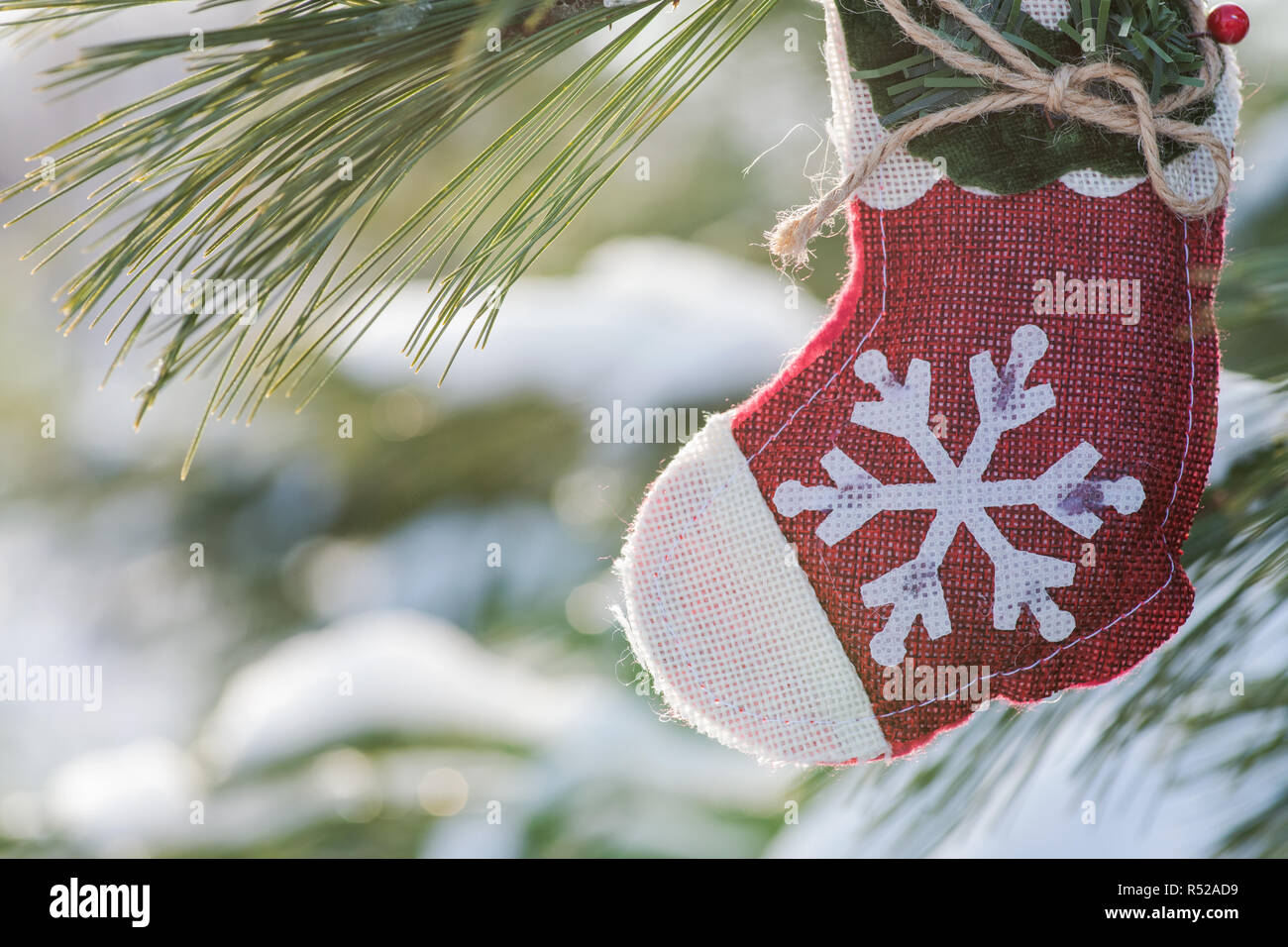 Winter Urlaub Dekoration Konzept: Schneeflocke häkeln Weihnachtsstrumpf und gefrorenen Schnee Tannenbaum, Zweige in Forest Park erhalten. Stockfoto