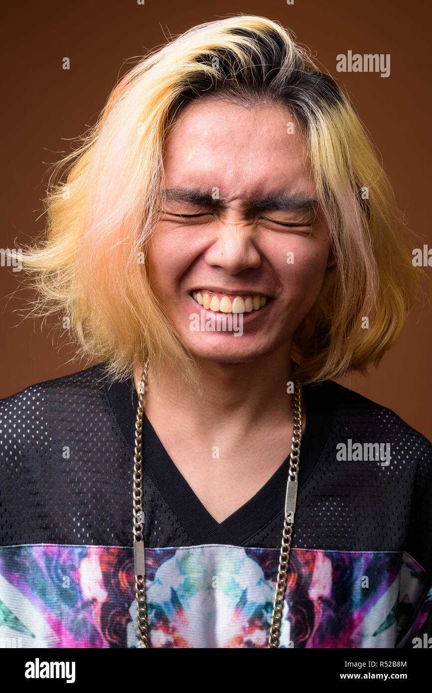 Junge asiatischer Mann lachend mit geschlossenen Augen Stockfoto