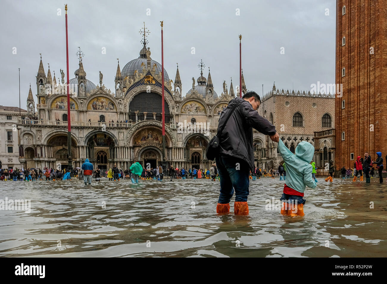 Venedig, Italien. 29. Oktober 2018. Papa begleitet seinen Sohn den überschwemmten St. Mark Square zu sehen. Dies war die höchste Flut des Jahrhunderts. Diese hohe t Stockfoto