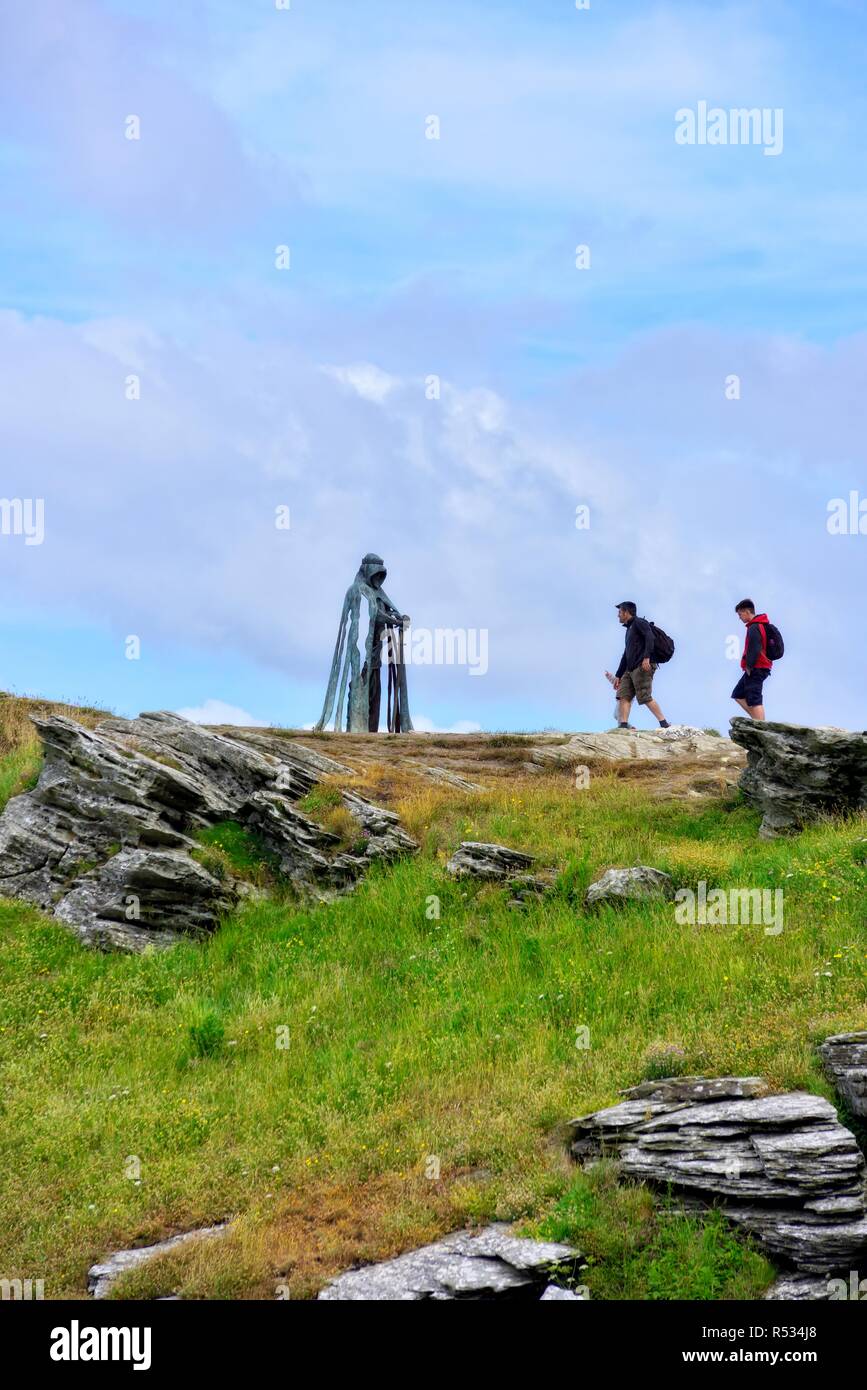 Touristen neben King Arthur eine 8 ft Bronze Skulptur des Künstlers Rubin Eynon, genannt Gallos kornischen Wort für Power, Burg Tintagel, Cornwall, Großbritannien Stockfoto