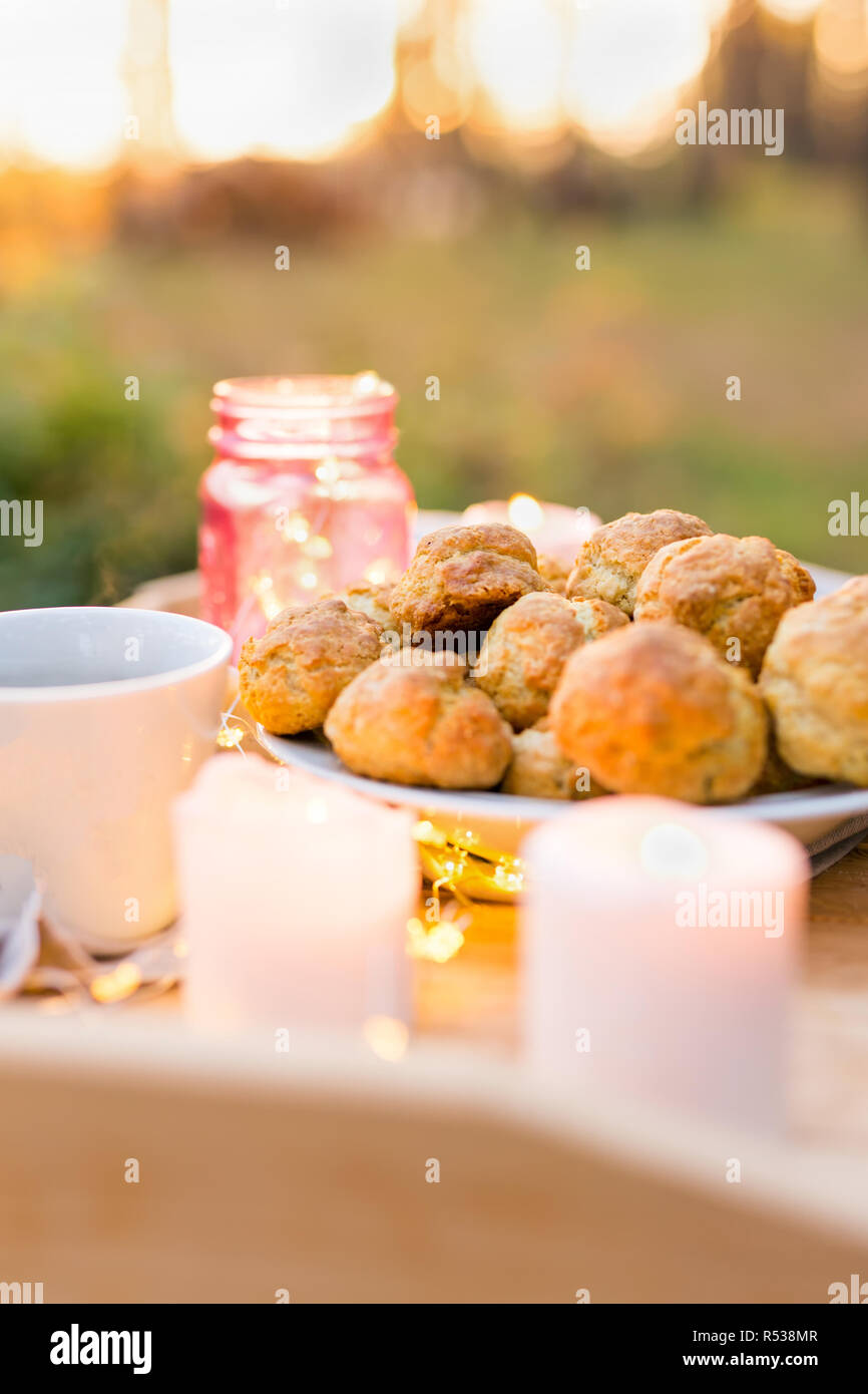 Leckere Cookies mit Kerzen auf einem hölzernen Fach im Freien Stockfoto